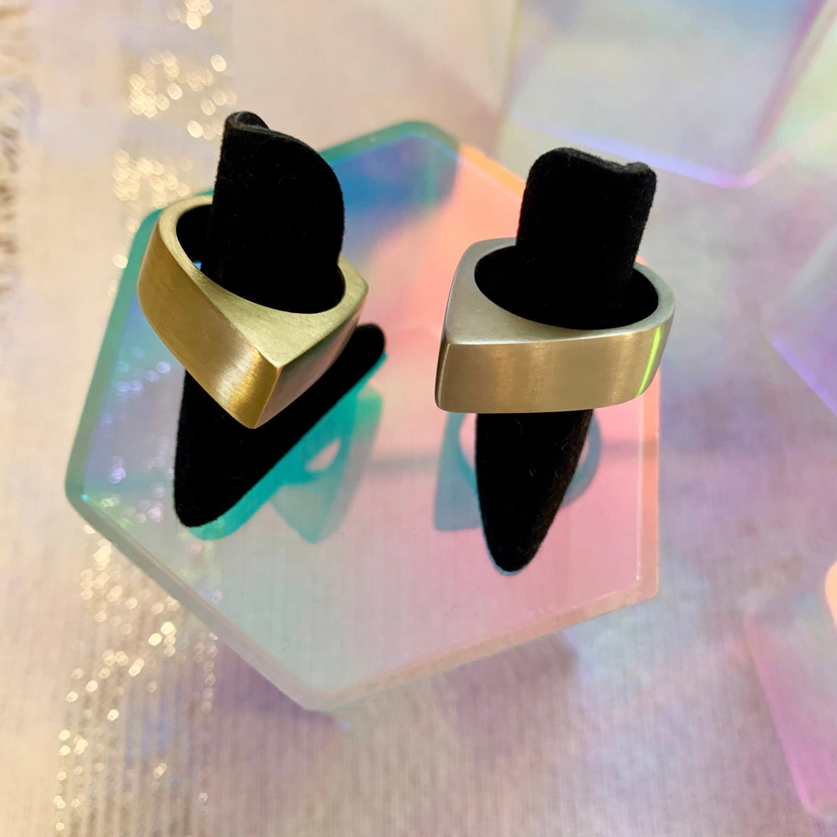 Pyramid Ring in eco-friendly brass and recycled sterling silver on ring sizers with colorful geometric prism props – Black Heart Jewelers