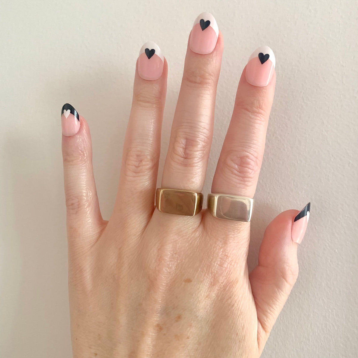Signet Ring in eco-friendly brass and recycled sterling silver, worn on two fingers with black heart nail art – Black Heart Jewelers