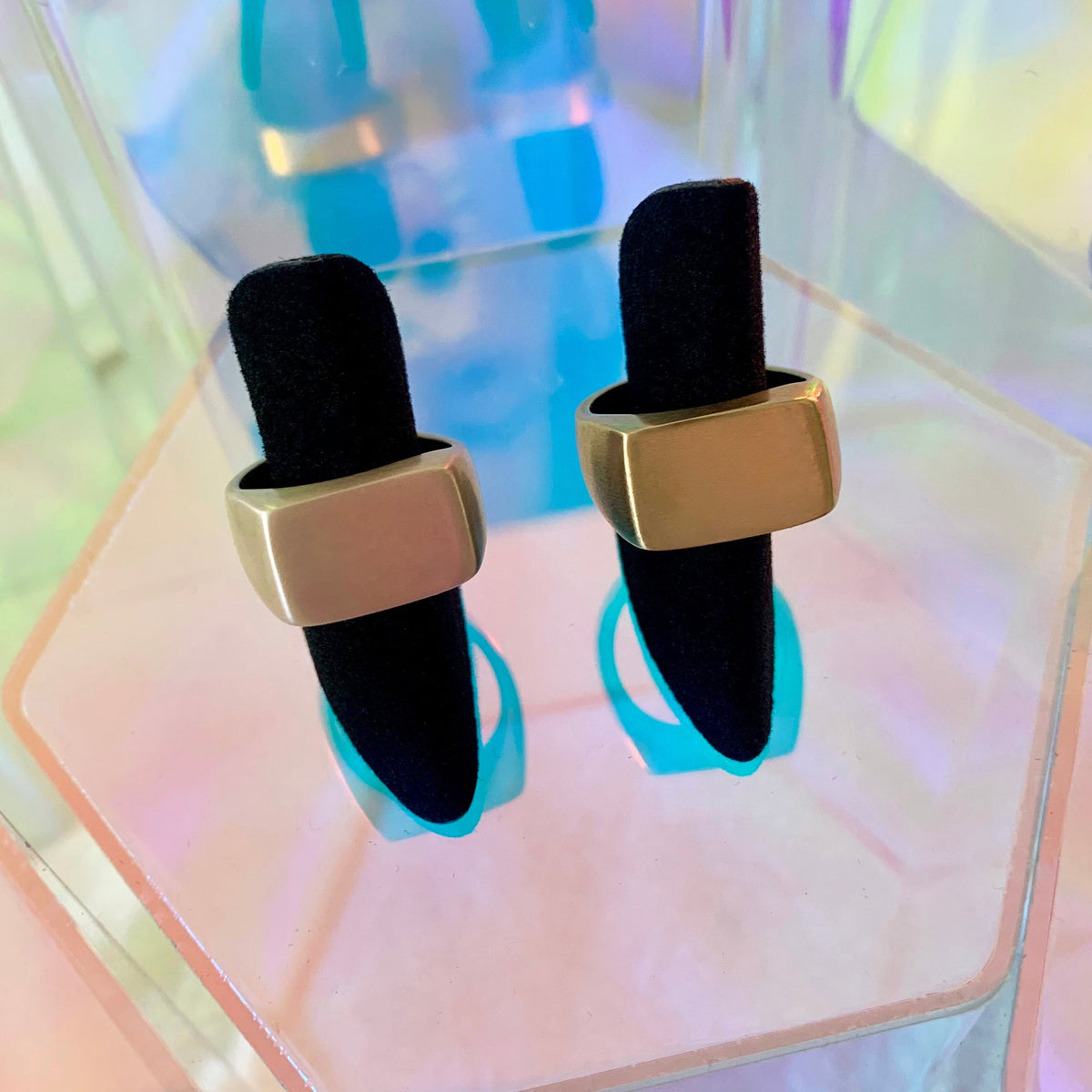 Signet Ring in eco-friendly brass and recycled sterling silver, two sizes displayed on black velvet ring holders against iridescent background – Black Heart Jewelers